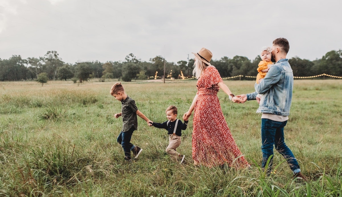Bilde av famile på en eng. Foto fra unsplash.com/@jessicarockowitz