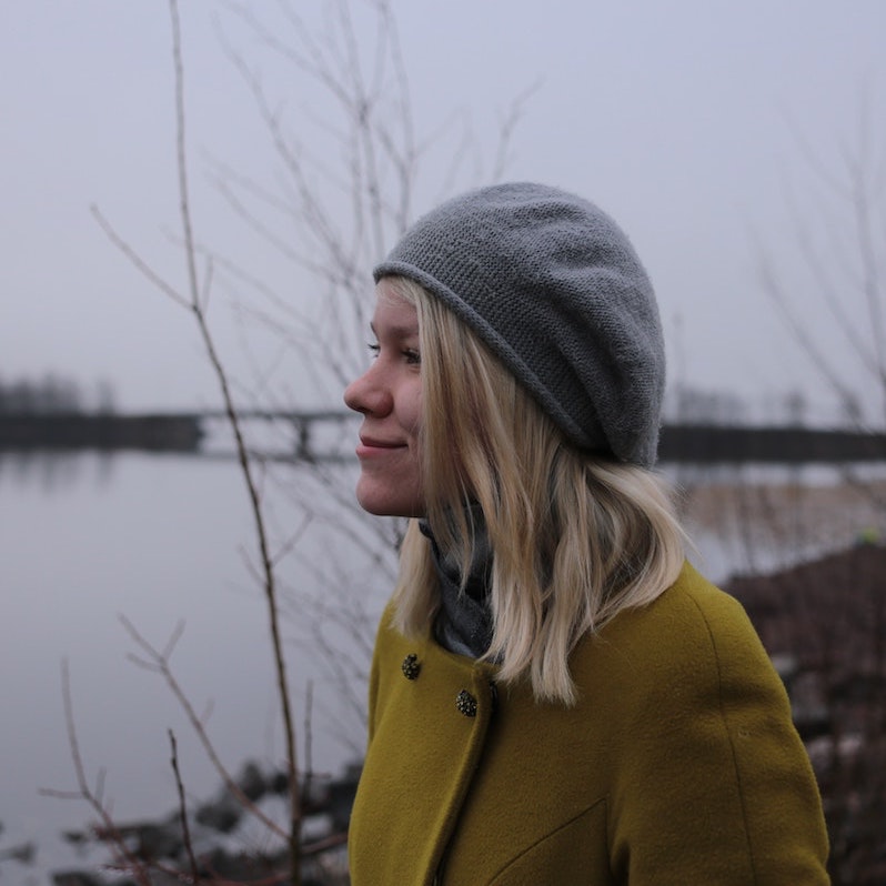 Bilde av ung dame med elv og bro i bakgrunnen. Foto av Luiza Sayfullina fra https://unsplash.com/@muzaluiza