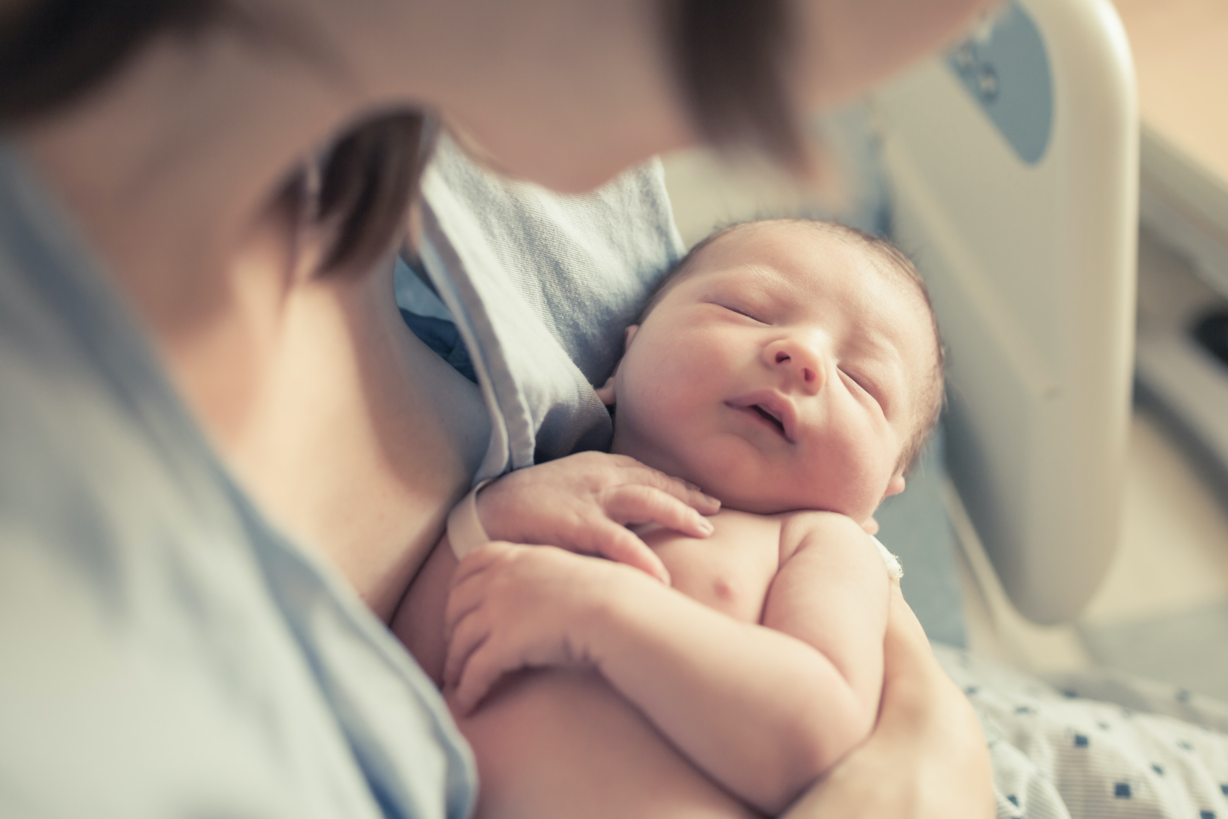 Mor som holder nyfødt baby i armene. Foto fra adobe stockphoto