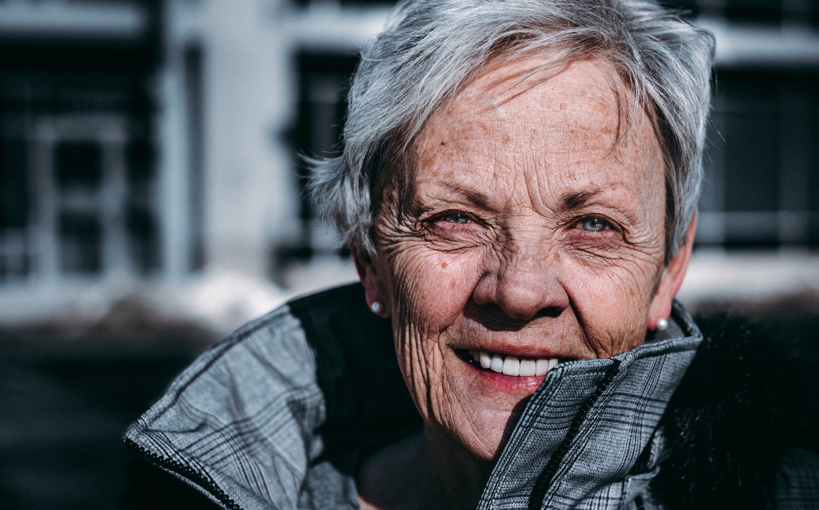 Bilde av smilende dame med grått hår. Foto: Photo av Ravi Patel på https://unsplash.com/@ravi_patel